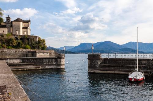 a small boat in the water next to a castle at Casa del Borgo "Aria & Acqua" sul Lago Maggiore in Maccagno Inferiore