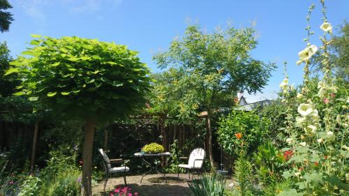a garden with a table and chairs and flowers at Overbosch in Bilthoven