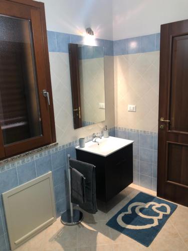 ein Bad mit einem Waschbecken und einem Spiegel in der Unterkunft Casa vacanze al parco in Giba