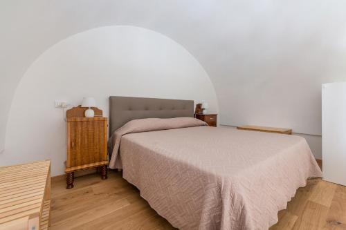 a bedroom with a bed in a white room at La Vite Bianca in Polignano a Mare