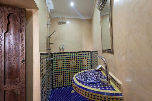 a bathroom with a blue and white mosaic sink at Riad Salman in Marrakech