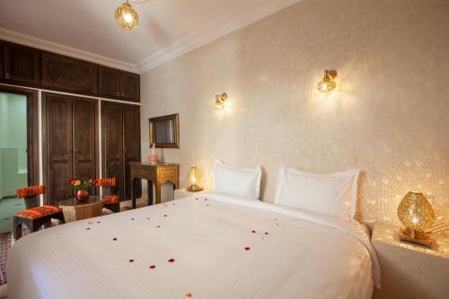 a bedroom with a large white bed with flowers on it at Riad Salman in Marrakech
