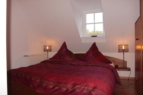een slaapkamer met een rood bed en een raam bij Gästehaus Herrenmühle in Freudenburg
