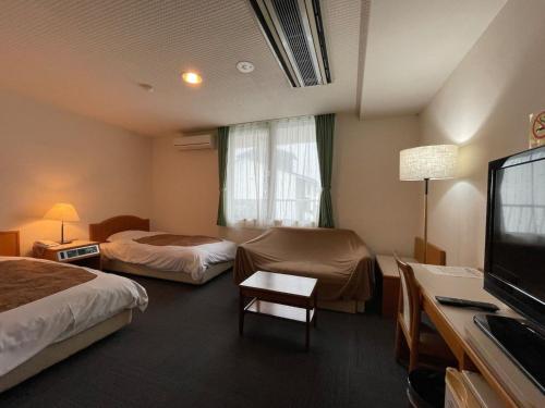 a hotel room with two beds and a flat screen tv at Hotel Ginsui - Vacation STAY 58202v in Kanayama