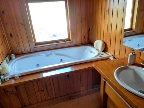 ein Badezimmer mit Badewanne und Waschbecken in der Unterkunft Casa Rincón Radales in San Martín de los Andes