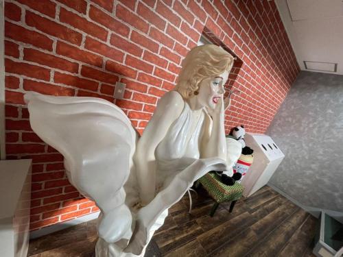 a statue of a woman sitting next to a brick wall at Marina Hotel Kaikuu - Vacation STAY 58502v in Kanayama