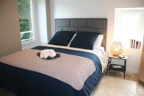 a bedroom with a bed with a bag on it at Les chambres d'hôtes de la croix bleue in Murinais