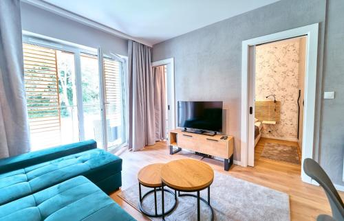 a living room with a blue couch and a table at LAGUNA Apartament Polanica Residence 17 in Polanica-Zdrój