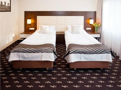 Łóżko lub łóżka w pokoju w obiekcie Hotel Fryderyk