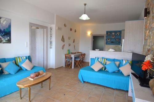 a living room with blue couches and a table at Kathara Bay Apartments in Faliraki