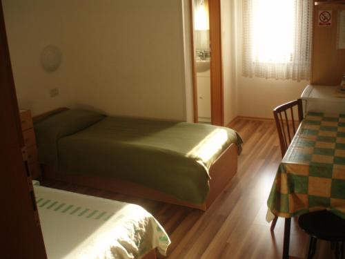 Habitación pequeña con 2 camas y ventana en Guest House Lidija, en Matulji