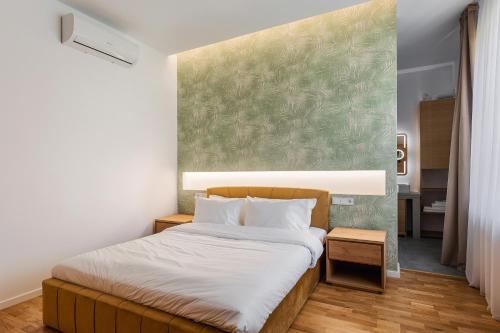 een slaapkamer met een bed en een groene muur bij CLUJ-NAPOCA coeur de ville in Cluj-Napoca