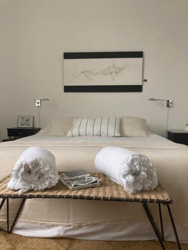 łóżko z 2 poduszkami i ręcznikami w obiekcie la boutique mj décoration vous propose de découvrir ses deux chambres d'hôtes w mieście Doué-la-Fontaine