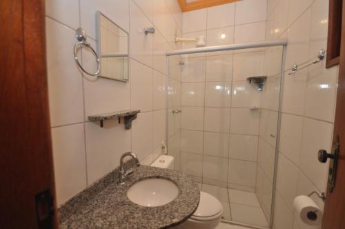 a bathroom with a sink and a glass shower at Pousada Rainha dos Anjos in Mariana