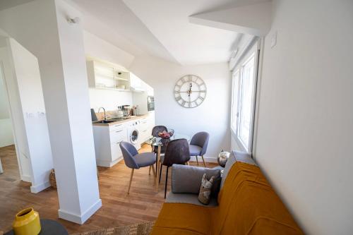 Il comprend un salon avec un canapé et des chaises ainsi qu'une cuisine. dans l'établissement Le Poulorio 12 - T2 - Proche Gare - dernier étage By Locly, à Lorient