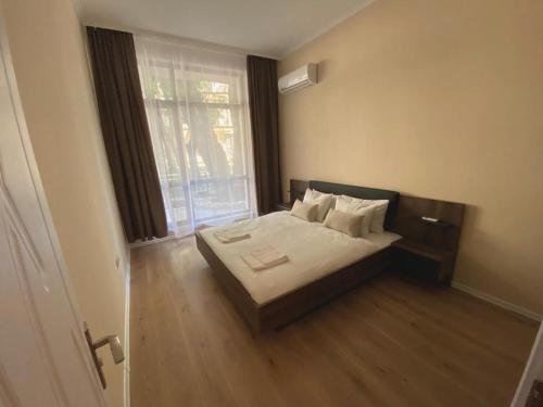 a bedroom with a bed and a large window at Rabi Park Residence in Varna City