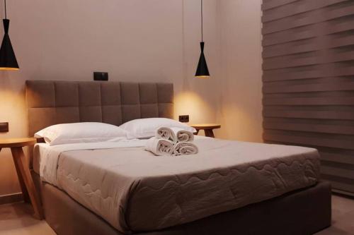 a bedroom with a large bed with two towels on it at Πολυτελές διαμέρισμα 2 Χαλκίδα-Παραλία Αυλίδος in Paralía Avlídhos