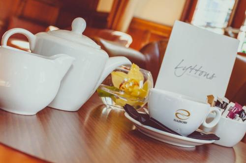 a table with two cups and a tea kettle at voco Letchworth Hall by IHG in Letchworth