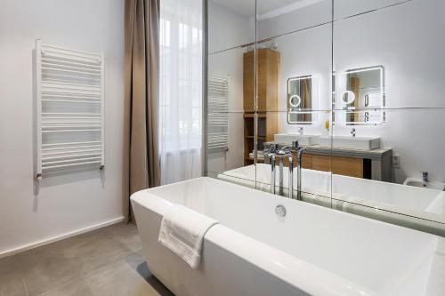 a white bathroom with a tub and two sinks at pedestrian street in city center for comfortable and beautiful stay with all comodities within walking distance in Cluj-Napoca