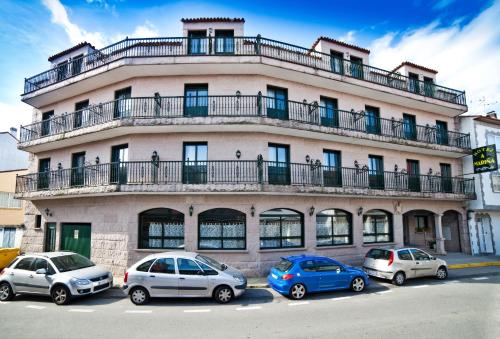 un edificio con coches estacionados frente a él en A Mariña, en Cambados