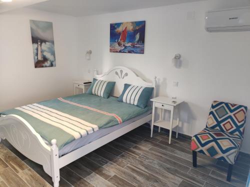 una piccola camera con letto e sedia di Pensiune Blue Coral Jurilovca a Jurilovca