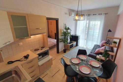 a kitchen and living room with a table and a couch at Vasilikis design appartment in Amalias