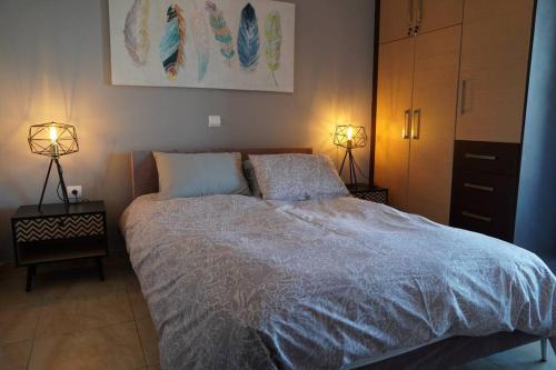a bedroom with a large bed with two lamps on it at Vasilikis design appartment in Amalias