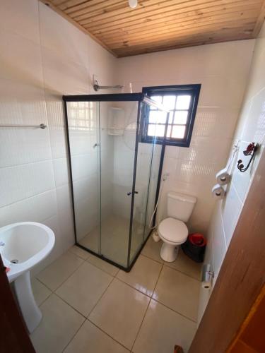 une salle de bain avec douche et toilettes dans l'établissement Chalé Flor da Serra, à Conceição da Ibitipoca