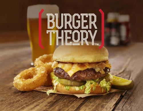 a hamburger and onion rings and a drink with a burger theory sign at Holiday Inn Omaha Downtown - Waterpark by IHG in Omaha
