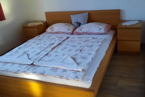 a bed with a wooden headboard and pillows on it at Andrea nyaralóház in Kővágóörs