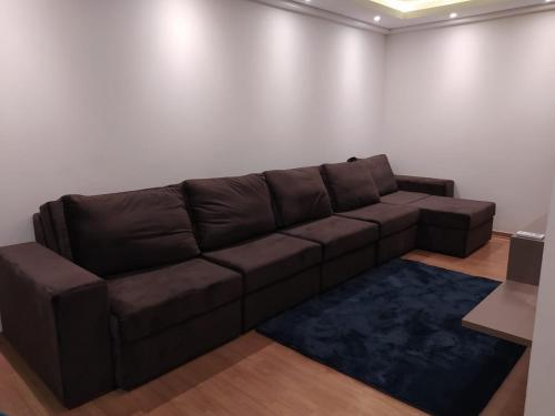 a brown couch in a room with a white wall at Conforto em Condomínio Frente Mar in Barra Velha