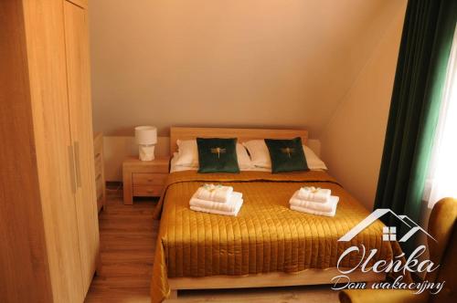 a bedroom with a bed with two towels on it at Dom Oleńka- Kaszuby, weekend, wakacje, sauna, jacuzzi, jezioro in Garcz