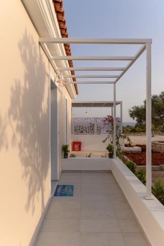 a patio with a pergola on a house at Dionisos Suites in Lixouri