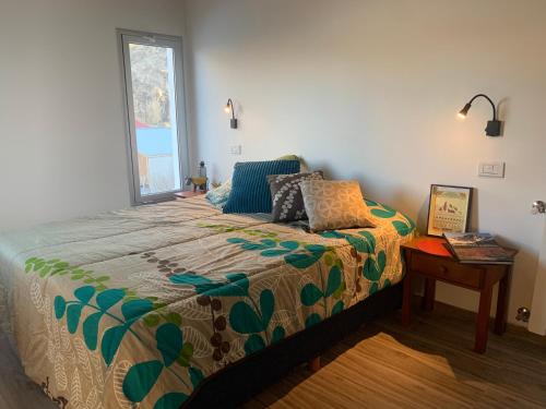 un dormitorio con una cama y una ventana en Meraki Lofts, en El Chaltén