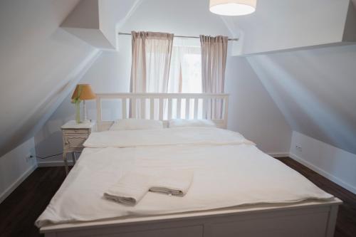een slaapkamer met 2 bedden met witte lakens en een raam bij Tatarska Zagroda - Agroturystyka Dolina Baryczy Noclegi - Domek Danielek in Krośnice