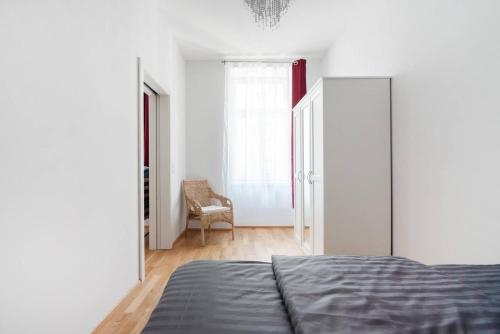 ein Schlafzimmer mit einem Bett und einem Stuhl darin in der Unterkunft Vienna Living Apartments - Raffaelgasse in Wien
