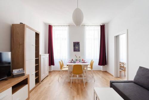 ein Wohnzimmer mit einem Esstisch und Stühlen in der Unterkunft Vienna Living Apartments - Raffaelgasse in Wien