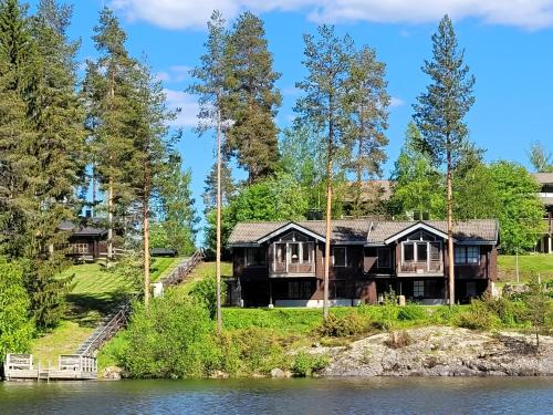 a large house on the shore of a lake at Villa Ozero in Tahkovuori