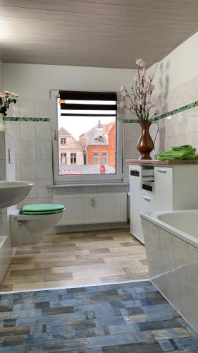 baño con lavabo y aseo y ventana en Ferienwohnung Zur Glewe, en Neustadt-Glewe