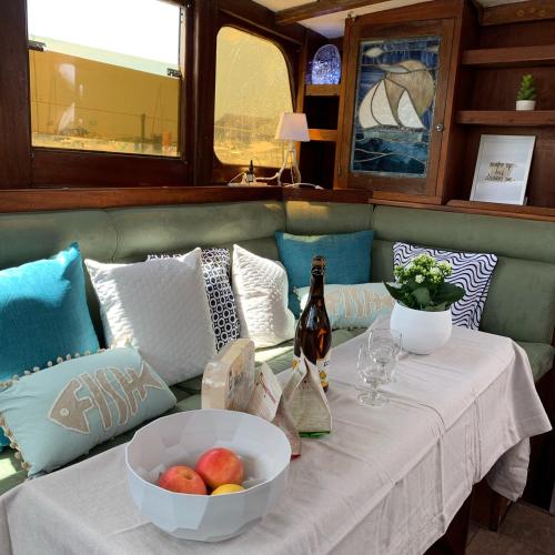 une table avec un bol de fruits et une bouteille de vin dans l'établissement Port Deauville Yacht vintage, à Deauville