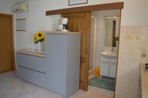 a bathroom with a sink and a counter with a flower on it at Rooms & Apartments Kvasić in Krk