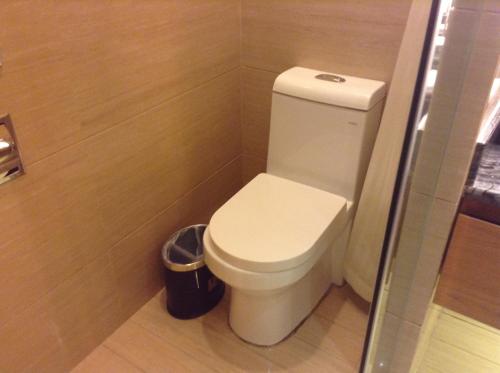 a bathroom with a toilet and a trash can at Shenzhen Shuidu Holiday Hotel, North Railway Station in Shenzhen