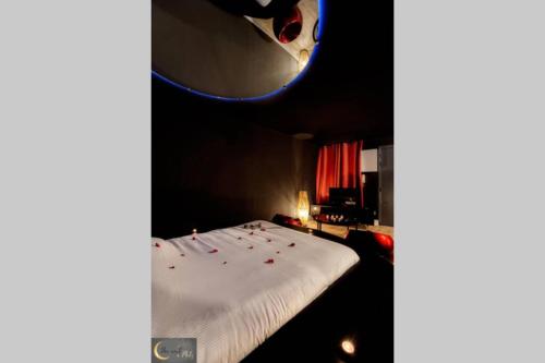 a bedroom with a white bed with candles on it at La chambre noire au coeur de Metz (unenuitametz) in Metz