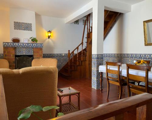 a living room with a fireplace and a table and chairs at Pátio da Muralha in Óbidos