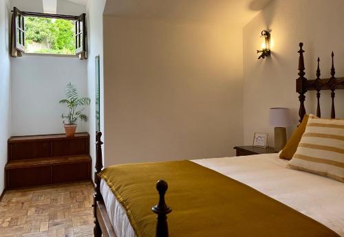 1 dormitorio con cama y ventana en Pátio da Muralha, en Óbidos