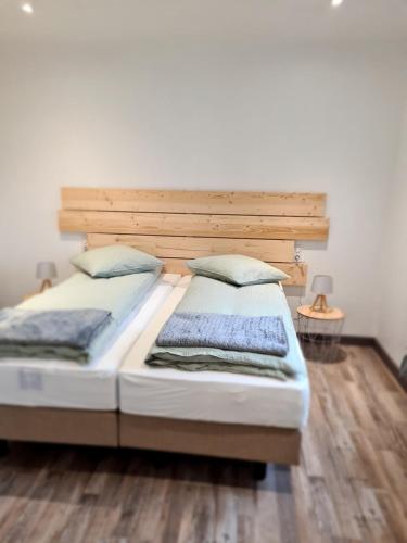 a bedroom with two beds and a wooden headboard at Le doux sapin in Lembach