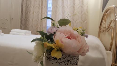 a vase of flowers sitting on a table in front of a mirror at Rome Lucia Apartment in Rome