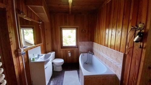 ein Badezimmer mit einer Badewanne, einem Waschbecken und einem WC in der Unterkunft Sępia Chata Dom Do Wynajęcia in Świeradów-Zdrój