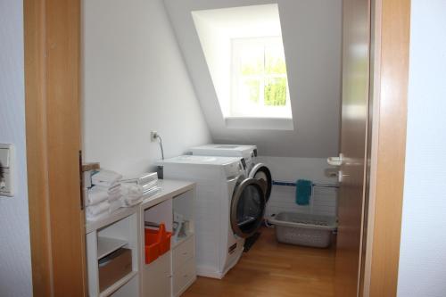 een wasruimte met een wasmachine en een raam bij Gästehaus Herrenmühle in Freudenburg
