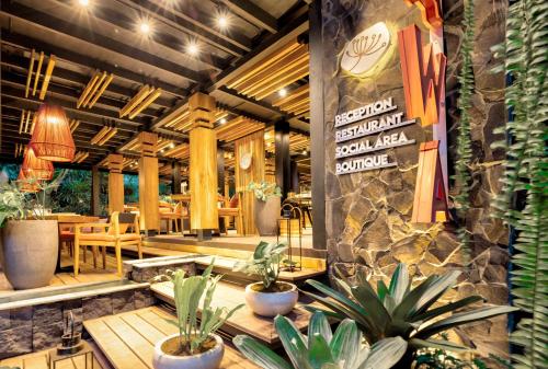 un restaurant avec des tables et des plantes en pot dans une pièce dans l'établissement aWà Beach Hotel, à Puerto Viejo